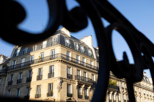 a building is seen through a metal fence at Pavillon Monceau in Paris