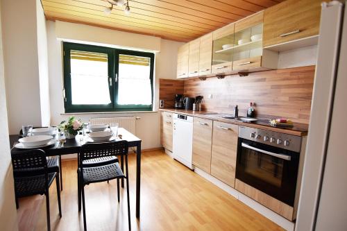een keuken met een tafel en een fornuis top oven bij 3 Room Apartment in Hellenthal in Hellenthal