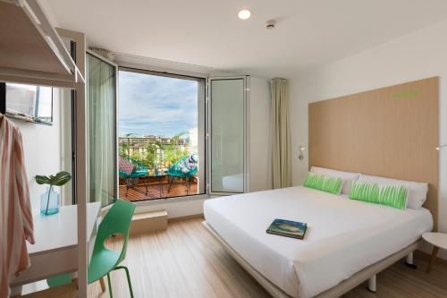 - une chambre avec un grand lit et une grande fenêtre dans l'établissement SmartRoom Barcelona, à Barcelone