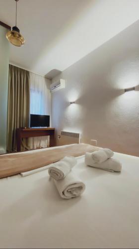 a bedroom with a bed with two towels on it at ODA Guest House in Korçë