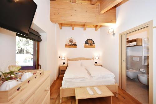 a bedroom with a large bed and a bathroom at Lo Chalet delle Ville in Varena