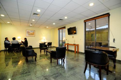 a waiting room with people sitting at tables and chairs at Hotel Diego De Almagro Calama in Calama