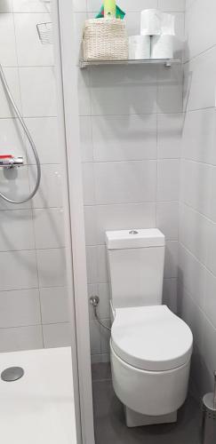 a white bathroom with a toilet and a shower at La petite maison in Le Bosc-Roger-en-Roumois