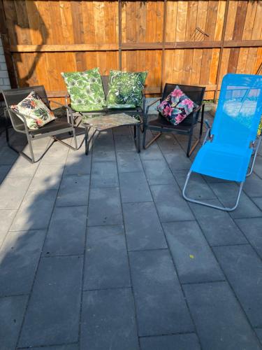 two chairs and a blue chair on a patio at Gästewohnung Mönchengladbach Rheindahlen in Mönchengladbach