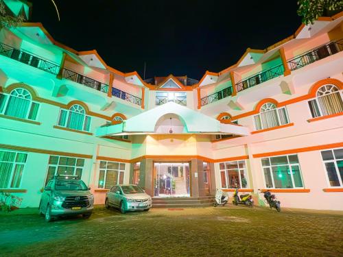 a building with two cars parked in front of it at The Byke Sunshine Grand in Ooty