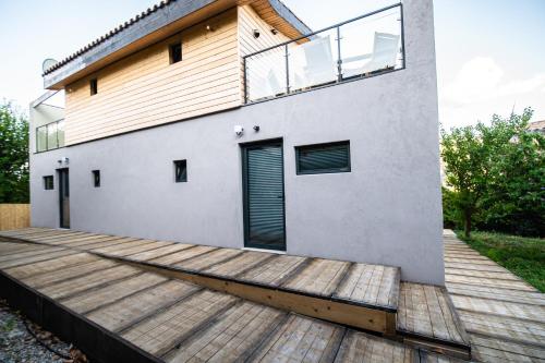 une maison avec une terrasse en bois devant elle dans l'établissement Halte Air et Go, à Marcoux