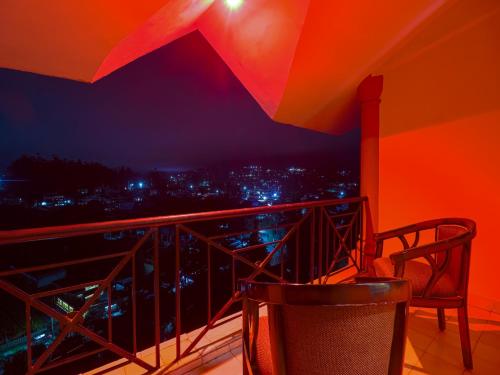 a balcony with a chair and a view of the city at The Byke Sunshine Grand in Ooty