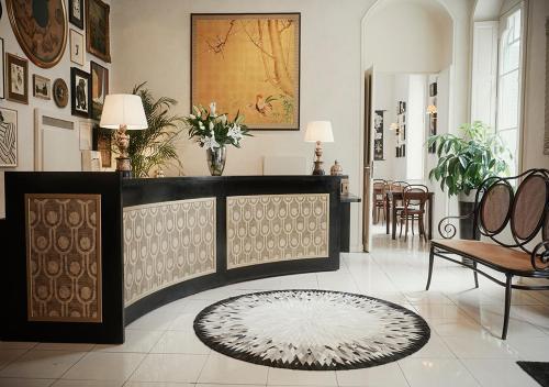 a lobby with a table and chairs and a rug at H&ocirc;tel Bristol Pau in Pau