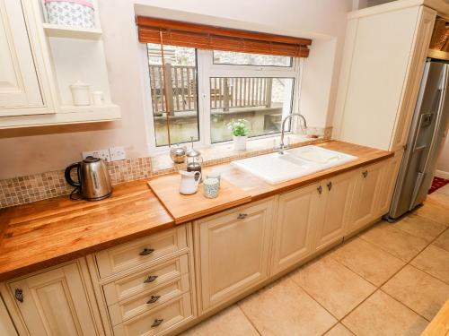 a kitchen with a sink and a window at The Old Bakery in Tenby