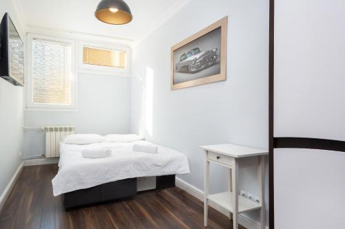華沙的住宿－Warsaw Apartament Rondo ONZ，一间小卧室,配有两张床和一张桌子