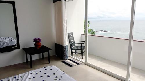 a room with a balcony with a view of the ocean at Talalla Leisure in Talalla