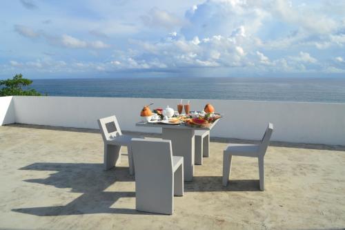 a table and chairs on a balcony with the ocean at Talalla Leisure in Talalla