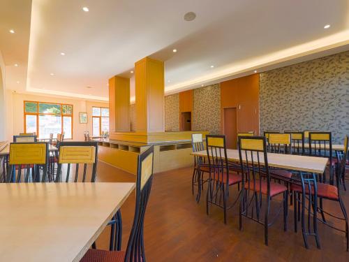 a restaurant with tables and chairs in a room at The Byke Sunshine Grand in Ooty