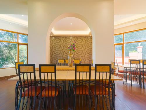 a dining room with a table and chairs at The Byke Sunshine Grand in Ooty