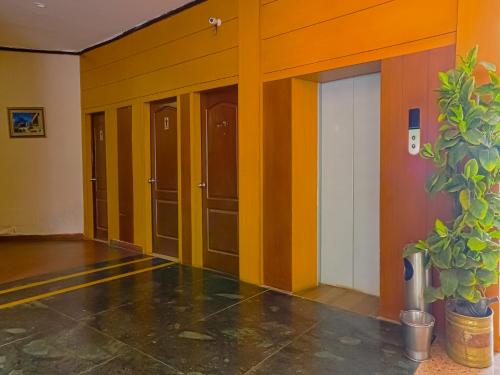 a row of doors in a room with a potted plant at The Byke Sunshine Grand in Ooty