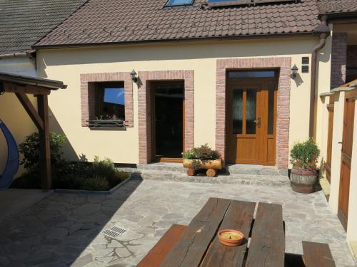 a patio with a wooden table in front of a house at Ubytování a apartmány Sluníčko in Lomnice nad Lužnicí