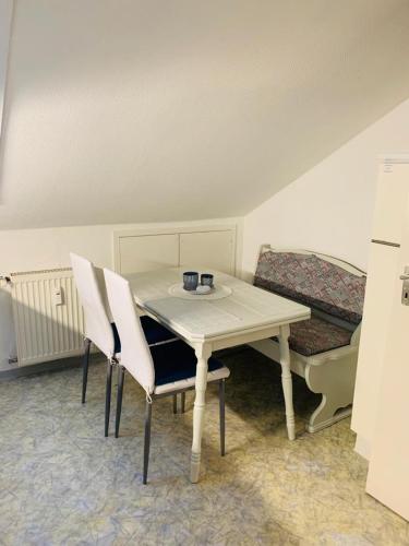 a table and chairs in a room with a couch at Ferienwohnung "Herzenslust" in Braunlage