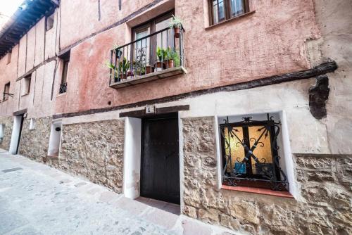 a brick building with two windows and a door at Casa Jarreta Centro Albarracin in Albarracín