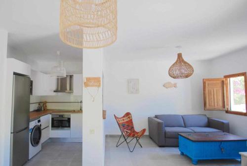 sala de estar con sofá azul y cocina en La Sirena Azul de Rodalquilar, en Rodalquilar