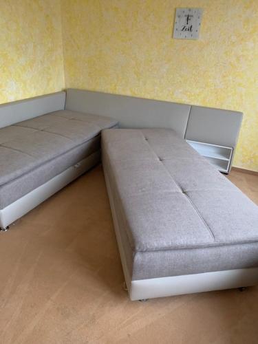 two beds in a room with a clock on the wall at Ferienwohnung "Herzenslust" in Braunlage