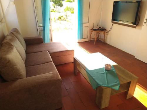a living room with a couch and a coffee table at Pérola de Sandy in Paderne