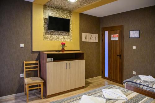 a bedroom with two beds and a tv on the wall at Villa Murite in Sapareva Banya
