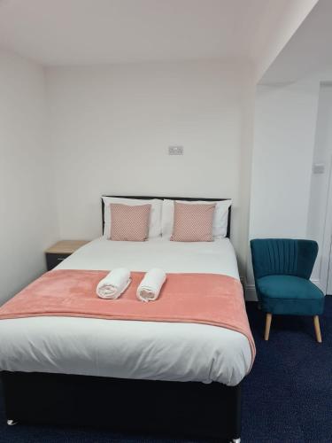 a bedroom with a bed and a blue chair at WNS Apartments Canary Wharf in London