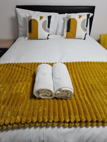 a bed with two towels sitting on top of it at WNS Apartments Canary Wharf in London
