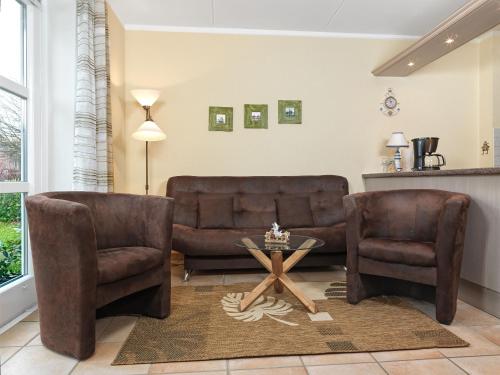 two leather chairs and a table in a living room at Buchenweg Inselnest in Insel Poel