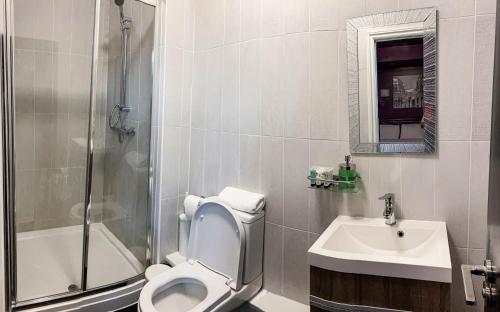 a bathroom with a toilet and a sink and a shower at WNS Apartments Canary Wharf in London
