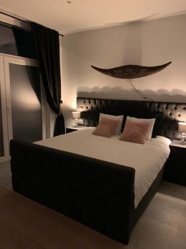 een slaapkamer met een groot bed met witte lakens en kussens bij Appartement op Italiëlei in Antwerpen