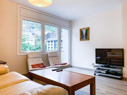 sala de estar con sofá, mesa y TV en Apartamento Perfección al lado de Caldea, en Escaldes-Engordany