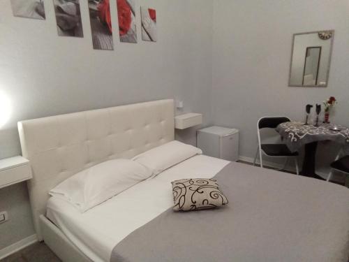 a bedroom with a white bed and a table at Vida Rooms Luxury in Palermo