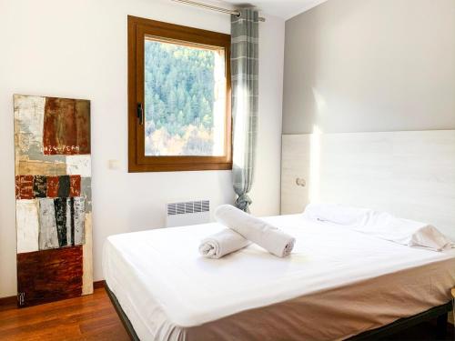 una camera con un letto bianco e una finestra di Apartamento moderno Estanyó con vistas en Arinsal a Mas de Ribafeta