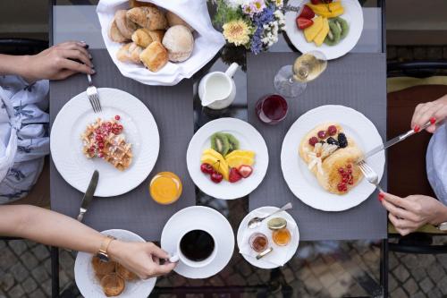 a table with plates of breakfast food on it at The Vintage House - Douro in Pinhão