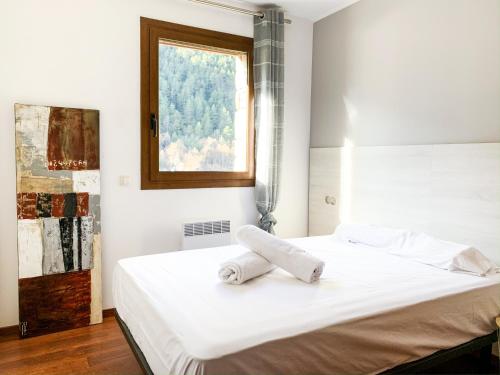 um quarto com uma cama branca e uma janela em Apartamento moderno Coma Pedrosa con vista en Arinsal em Arinsal