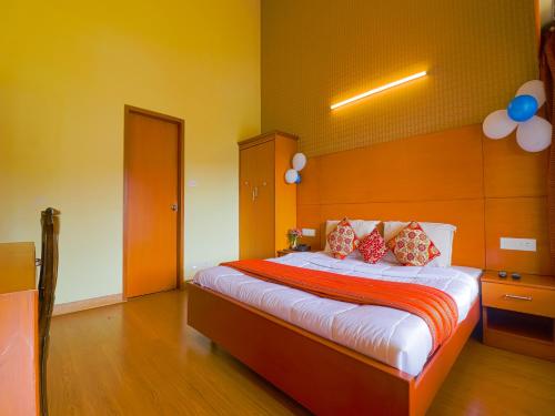 a bedroom with a bed with red pillows on it at The Byke Sunshine Grand in Ooty