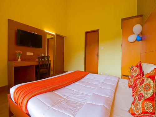 a bedroom with a large bed and a desk at The Byke Sunshine Grand in Ooty