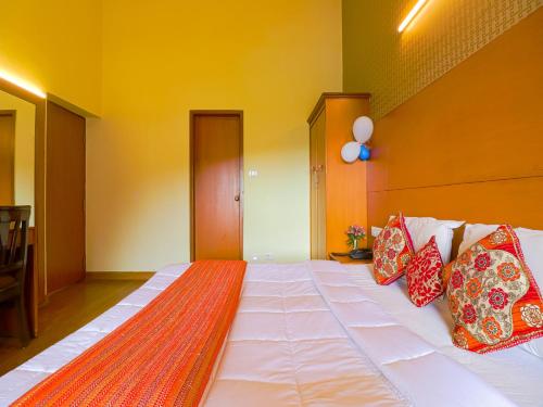 a large bed with pillows on it in a room at The Byke Sunshine Grand in Ooty