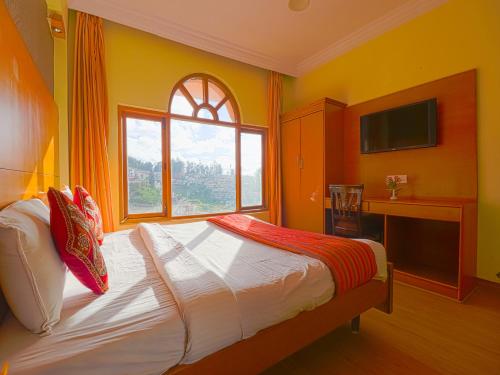 a bedroom with a bed and a large window at The Byke Sunshine Grand in Ooty