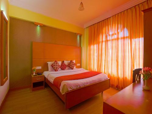 a bedroom with a bed and a window at The Byke Sunshine Grand in Ooty