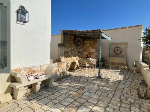a patio with chairs and a table in a building at Tenuta Mosè Charming House&Relais Gallipoli in Gallipoli