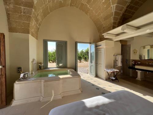 duża łazienka z wanną i pianinem w obiekcie Tenuta Mosè Charming House&Relais Gallipoli w mieście Gallipoli