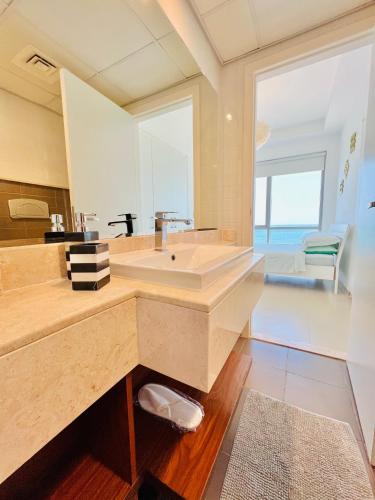 a bathroom with a sink and a large window at Luxurious 2 bedroom Beachfront Apartment - direct seaview in Ras al Khaimah