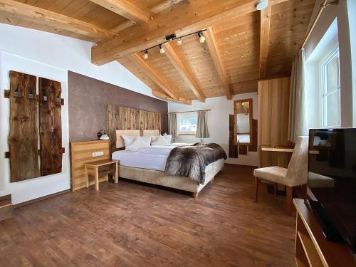 1 dormitorio con 1 cama en una habitación con techos de madera en Haus Buchhammer, en Sankt Anton am Arlberg