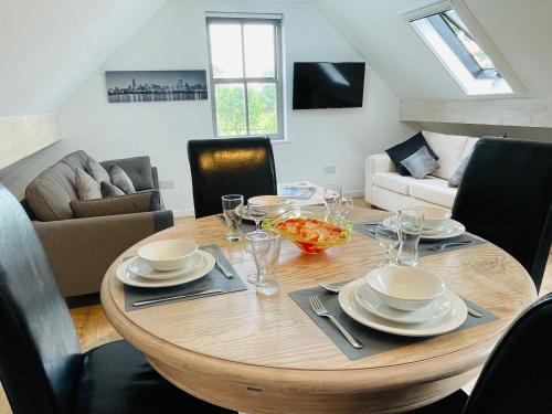 un tavolo in legno con sedie e una sala da pranzo di Silverwood Coach House a Frome