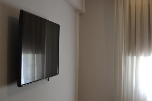 TV de pantalla plana colgada en la pared en el Hotel Cervantes, en Mendoza
