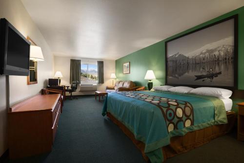 a hotel room with a bed and a flat screen tv at Super 8 by Wyndham Salmon in Salmon