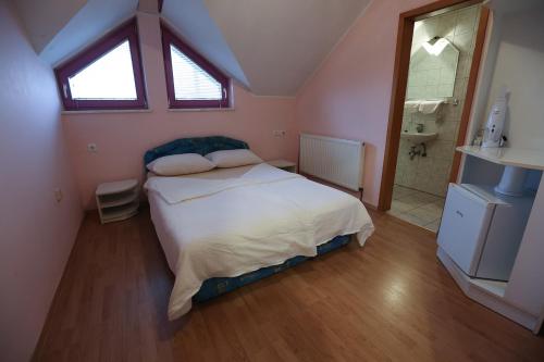 a bedroom with a large bed and a bathroom at Hostel - Rooms Kaj & Kaja in Orehova vas 