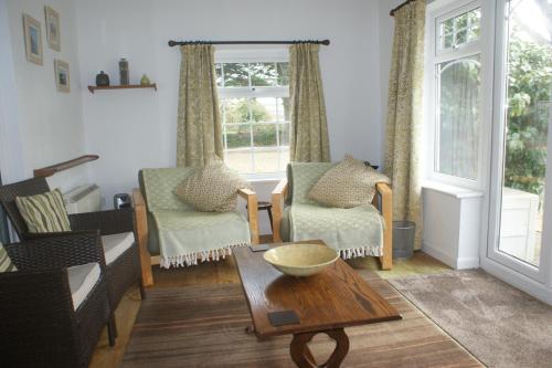 a living room with two chairs and a table at Nanis in Crantock